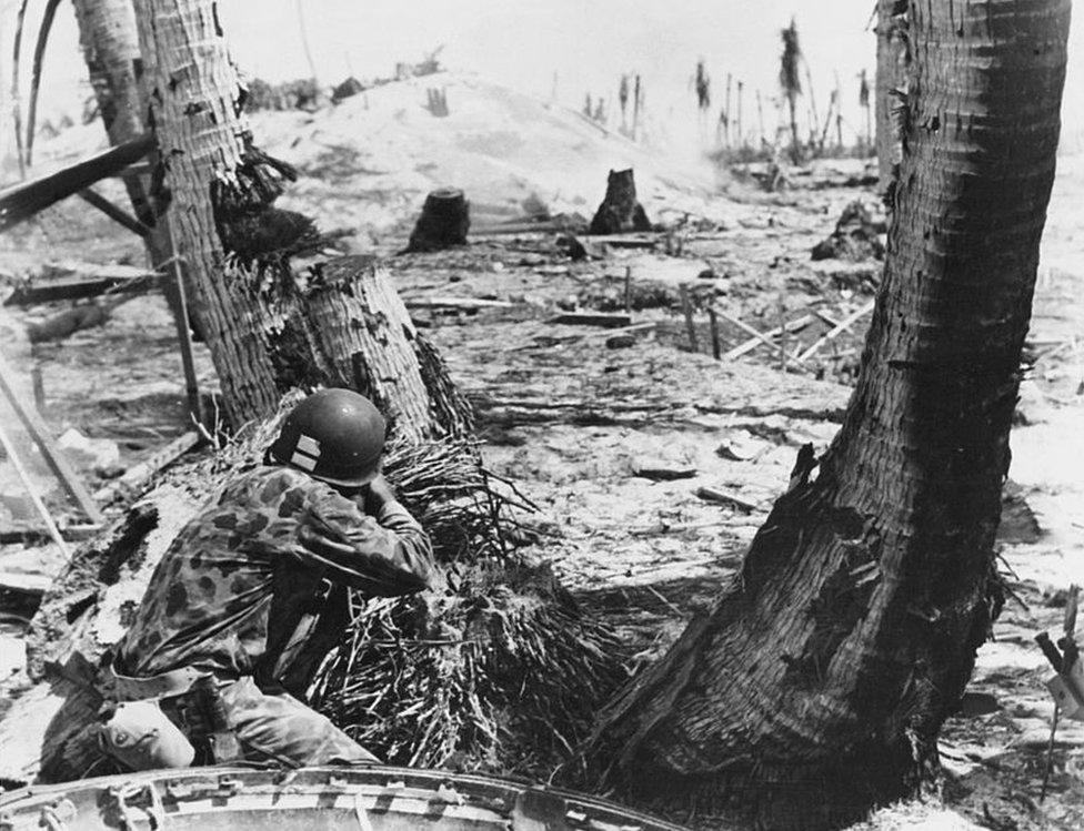 A US Marine fires at a Japanese pillbox bunker