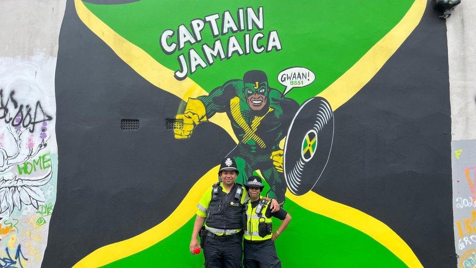 Police officers in front of mural