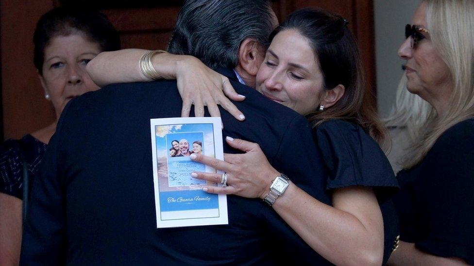 Mourners hug at the funeral