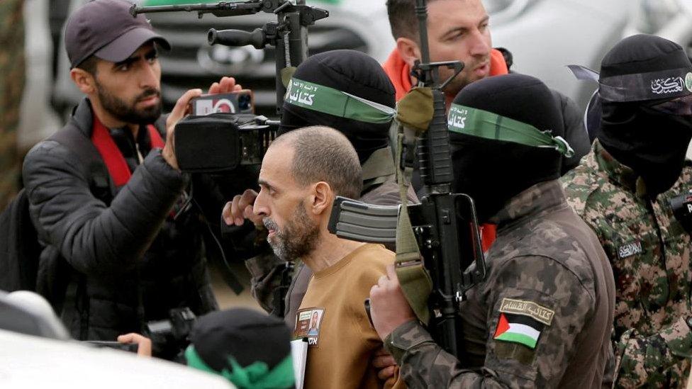 Eli Sharabi was freed, surrounded by masked Hamas gunmen