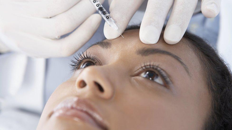 Woman having filler injection in her forehead