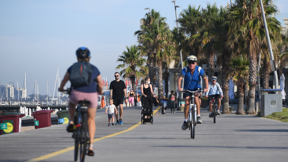 People cycling along a promenade in Melbourne during the February lockdown