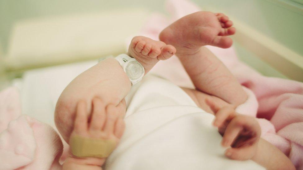 A baby in a hospital cot