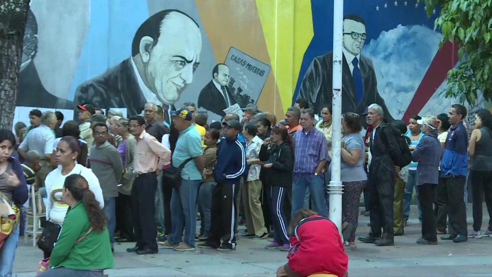 Voters queue outside a polling station