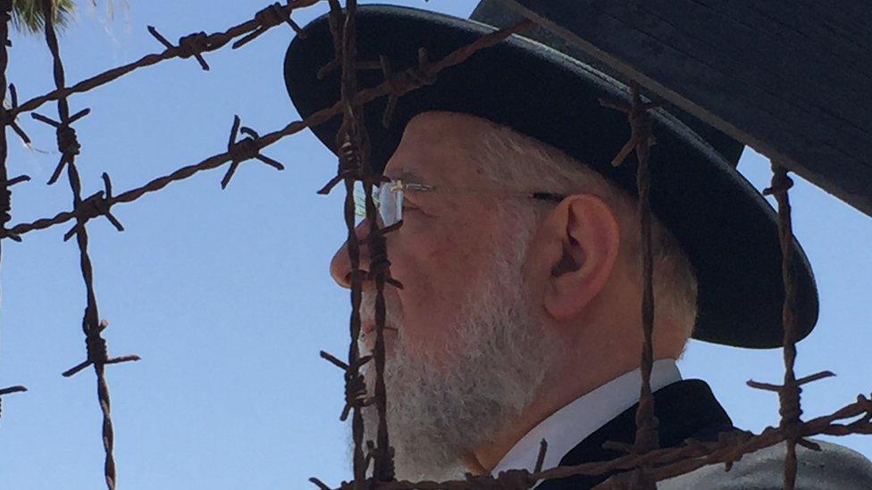 Rabbi Meir Lau looks through the barbed wire at the former British internment camp at Atlit