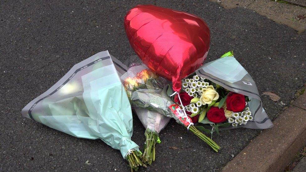 Flowers and a red balloon left at the scene on Titmuss Avenue