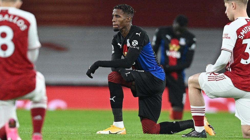 Wilfried Zaha taking a knee.