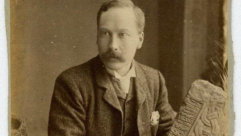 PMC Kermode holding a piece of a Manx stone cross