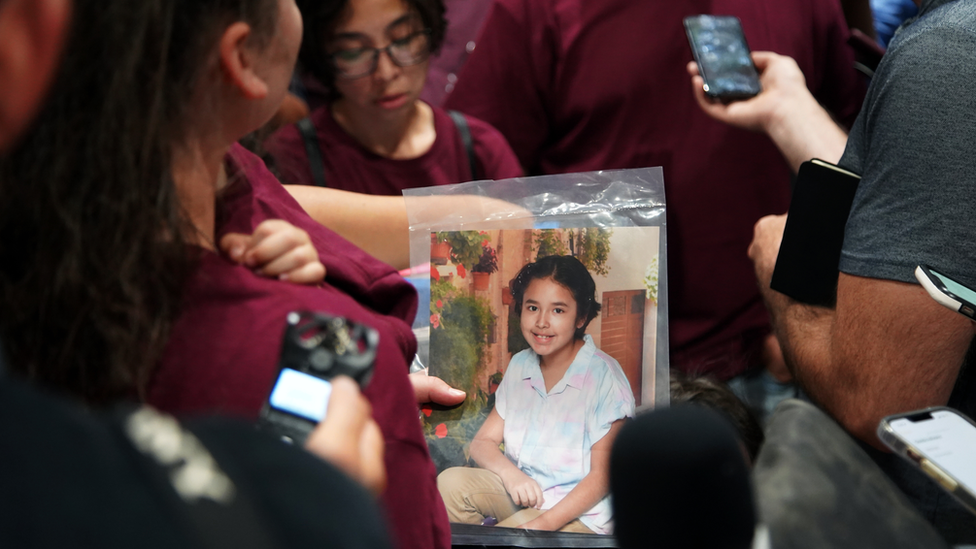 Mother holds photo of child