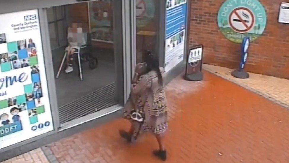 Still of CCTV footage of woman walking into a hospital