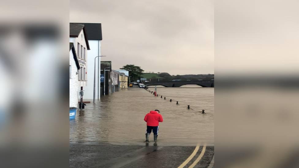 man walking through flooded street