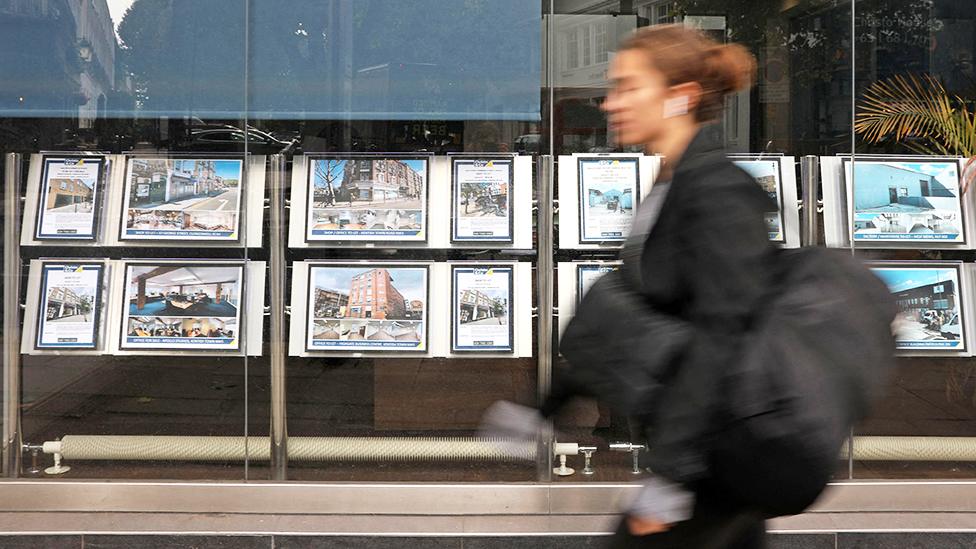 A woman walks past an estate agents window in September 2022