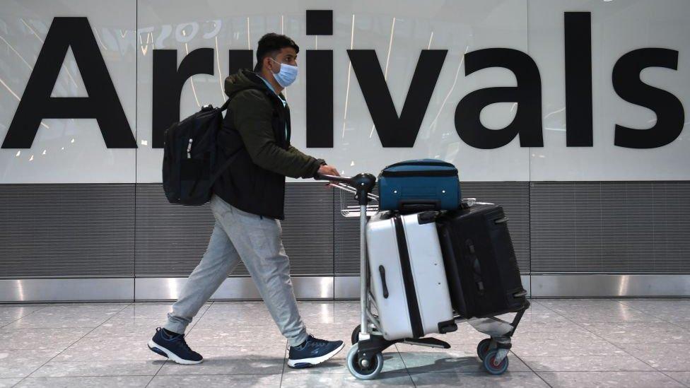 Passenger arriving in Heathrow Airport wearing a face mask