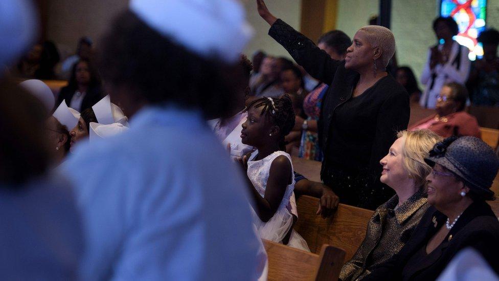 Democratic candidate Hillary Clinton (2nd R) on a pew during a Sunday service at a church in Charlotte, North Carolina