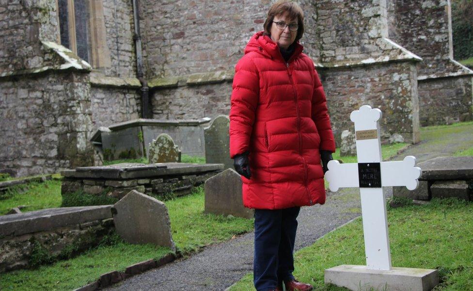 Janet Bradshaw by the grave of Leonie Demoulin at Laugharne