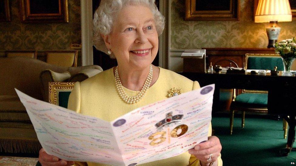 Queen Elizabeth II sitting in the Regency Room at Buckingham Palace in London looking at some of the cards which have been sent to her for her 80th birthday.