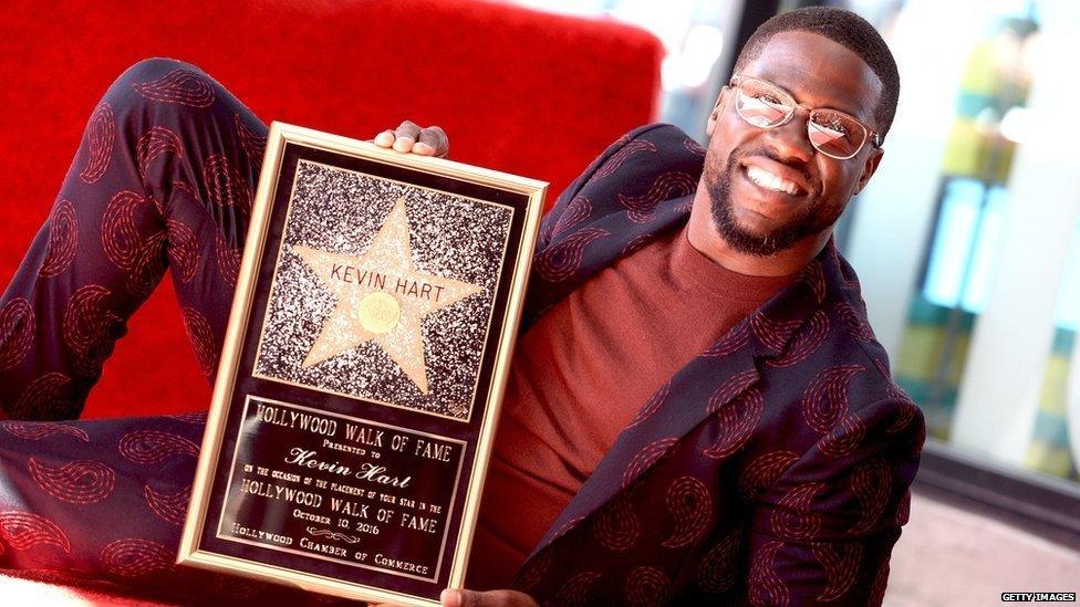 Kevin Hart holding his Hollywood Walk of Fame plaque