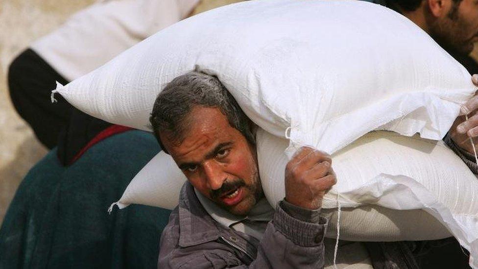 A Palestinian man carries sacks of flour supplied by the UN in Gaza City. File photo