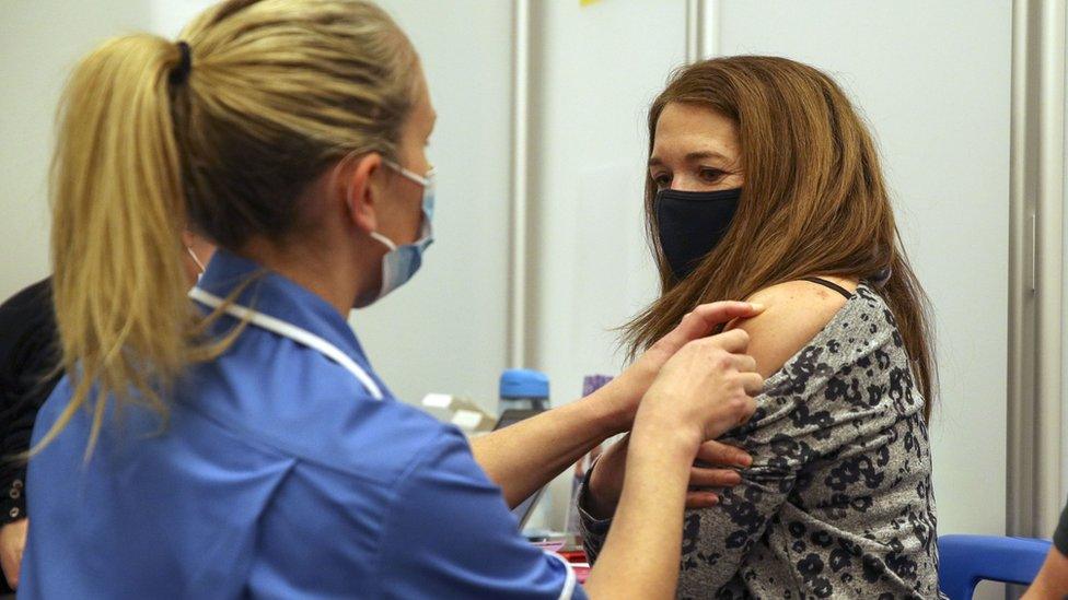 A nurse administers a coronavirus vaccine