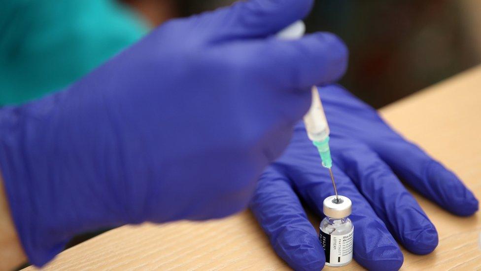 Pfizer vaccine being drawn into syringe