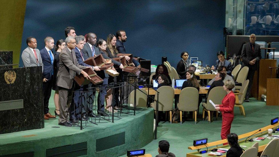 UN officers hold up empty ballot boxes before collecting ballots from delegates at the election of new members of the UN Human Rights Council on October 12, 2018 at the UN in New York.