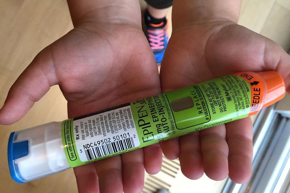 A young person holding an EpiPen