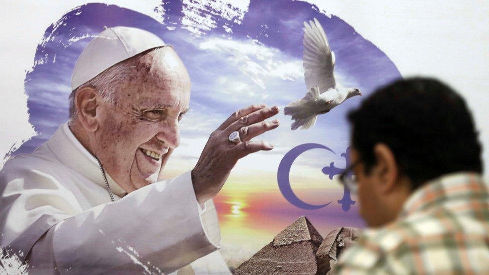 A man looks over to a poster of Pope Francis at a news conference ahead of the pope"s visit in Cairo, Egypt April 6, 2017