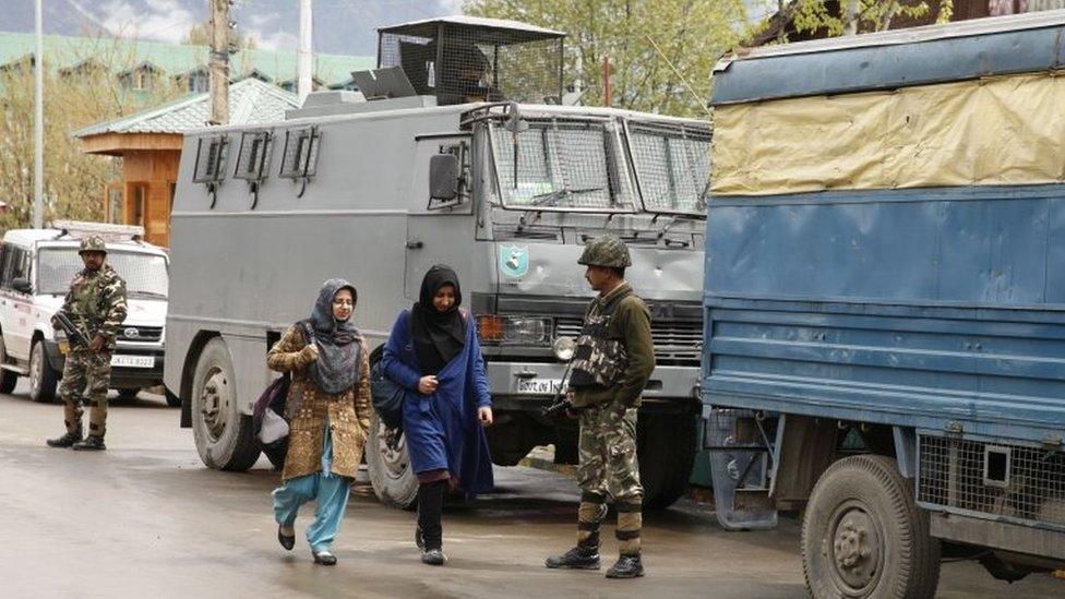 Students walk past an Indian paramilitary soldiers of Central Reserve Police Force (CRPF) at the National Institute of Technology (NIT) in Srinagar, summer capital of Indian administered Kashmir,