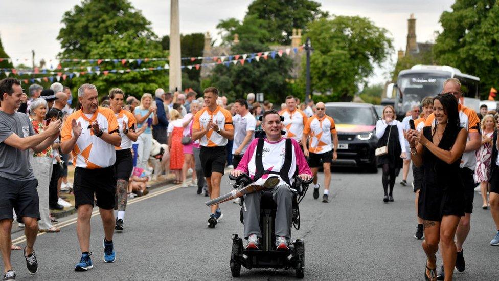 Baton bearer Stephen Murray carries the Queen's Baton during the Birmingham 2022 Queen's Baton Relay at a visit to Broadway on July 22, 2022 in Worcestershire