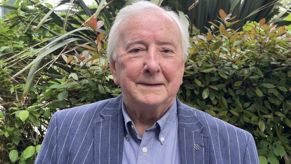 Maurice Taylor photographed in front of foliage