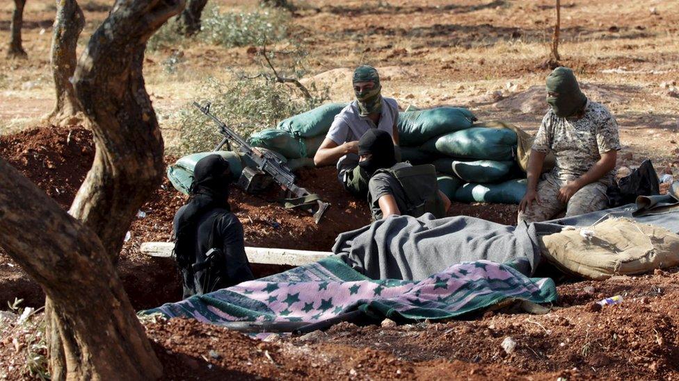 Members of al-Qaeda's Nusra Front sit in a trench in north-west Syria