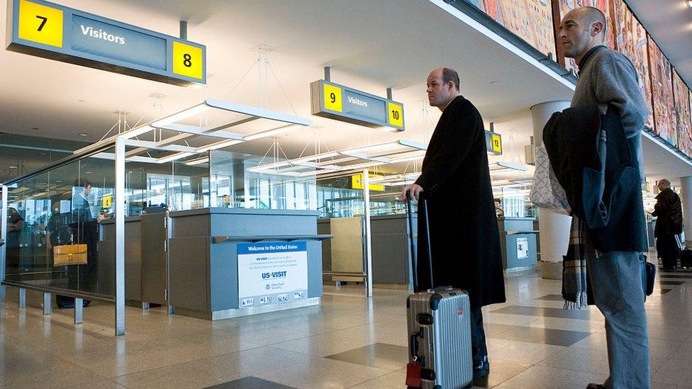 People wait to enter the US at JFK airport in New York