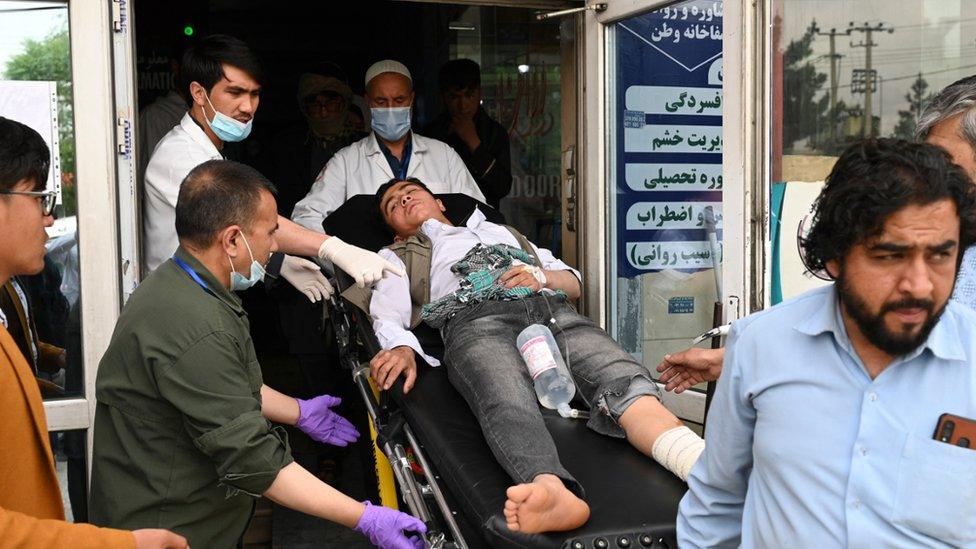 Medical staff move one of the wounded on a stretcher inside a hospital after blasts rocked a boys' school in a Hazara neighbourhood in Kabul on April 19, 2022.