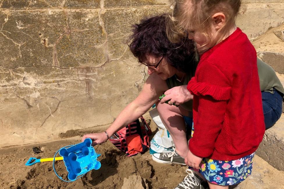 Three-year-old Scarlet builds a sandcastle on the beach at Rhyl