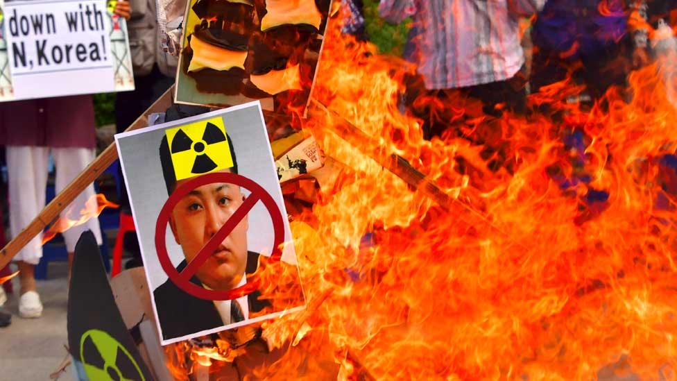 South Korean activists set fire to a portrait of North Korean leader Kim Jong-Un during a protest in Seoul