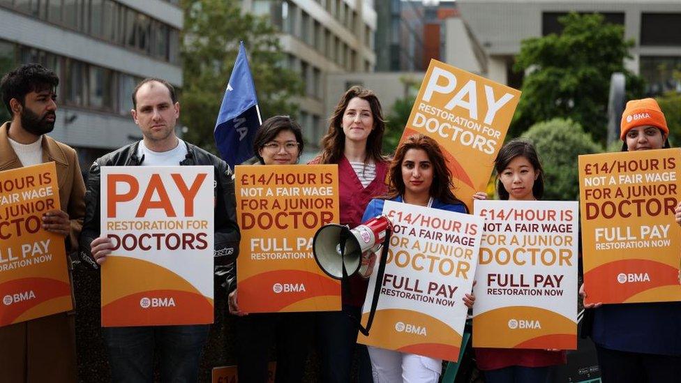 Doctors on strike hold placards calling for higher pay