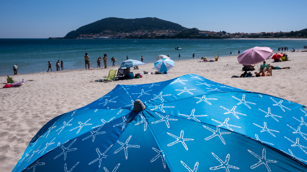 Cape Finisterre seen from Langosteira beach, on the Costa da Morte, place of the Camino de Santiago, is a coast frequented by tourists and bathers from the area, seen on 15 July 2021, Finisterre, Galicia, Spain.