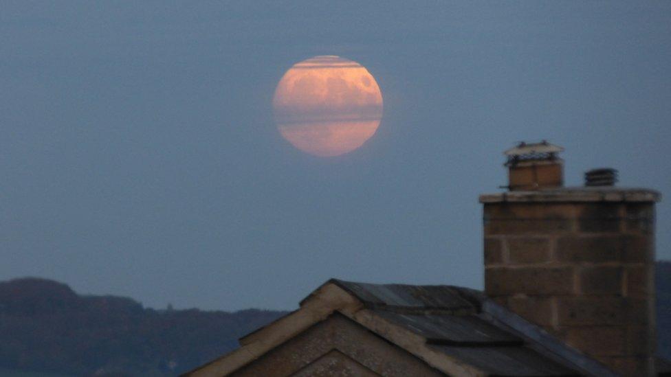 The full moon over a rooftop in Bath