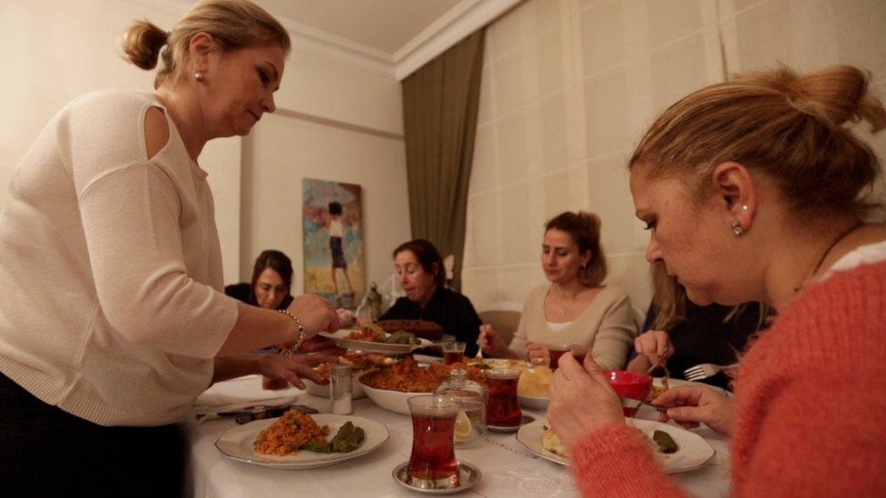 Emel Resuloglu serves her friends during their monthly get-together