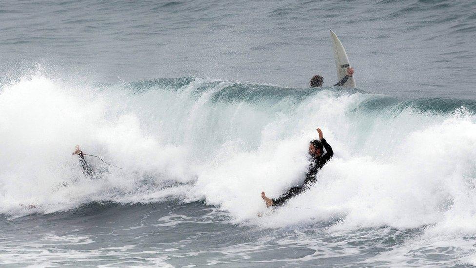 Surfers take to the water at Cottesloe beach in Perth, to take advantage of unusually large waves created by a storm, the result of Tropical Cyclone Mangga meeting a cold front off the West Australian coast.