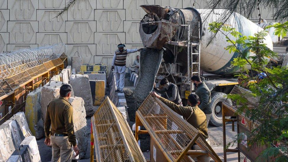 Concrete being poured between stone barricades