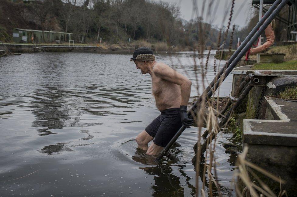 A man climbs into water