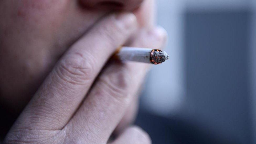 A close-up of an anonymous person smoking