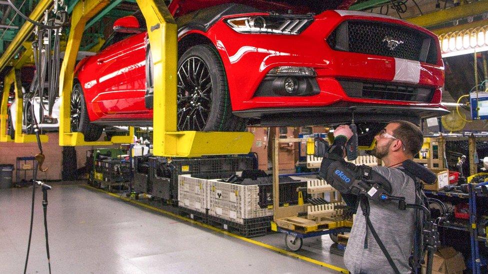 A Ford factory on the underside a red car