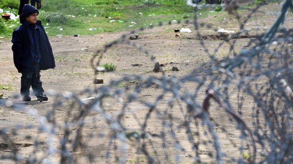 A young migrant boy waits in front of the Hungarian border fence at the Tompa border station transit zone on 6 April 2017 as the Hungarian Interior Minister Sandor Pinter (not pictured) presents the camp to the media