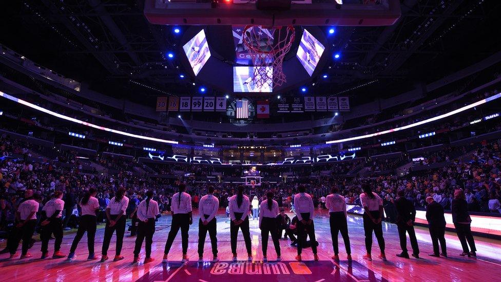 Minnesota Lynx players stand up for the National Anthem as the Los Angeles Sparks stay in their locker room before a WNBA game.