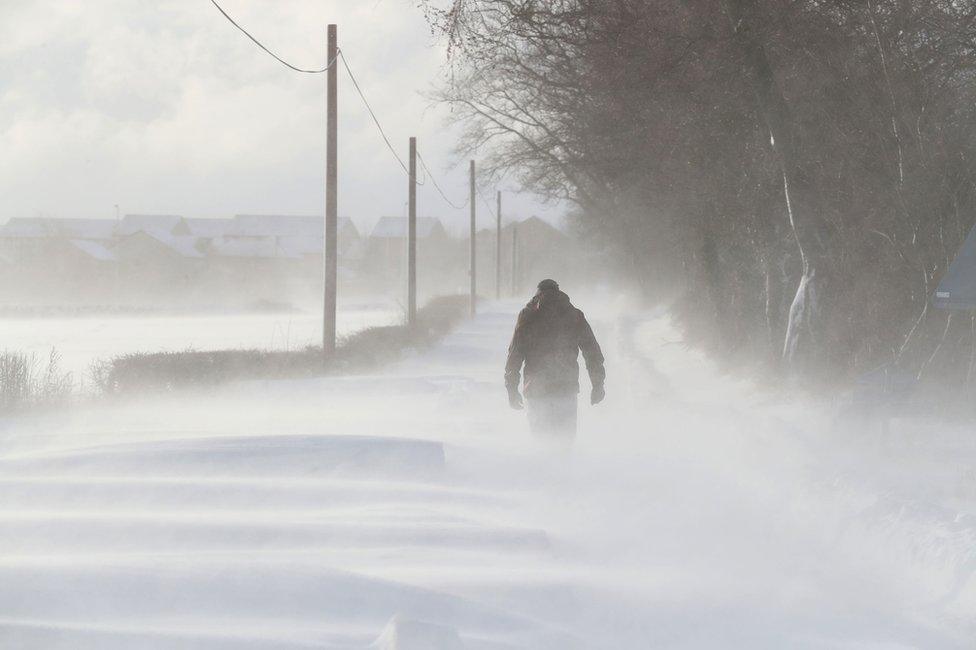 A man walking in snowy conditions in Larbert, Scotland