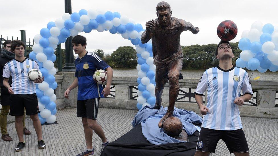 Youths play with footballs next to a sculpture of Argentina's forward Lionel Messi, after it unveiling by Buenos Aires Mayor Horacio Rodriguez Larreta in Buenos Aires, Argentina, on June 28, 2016