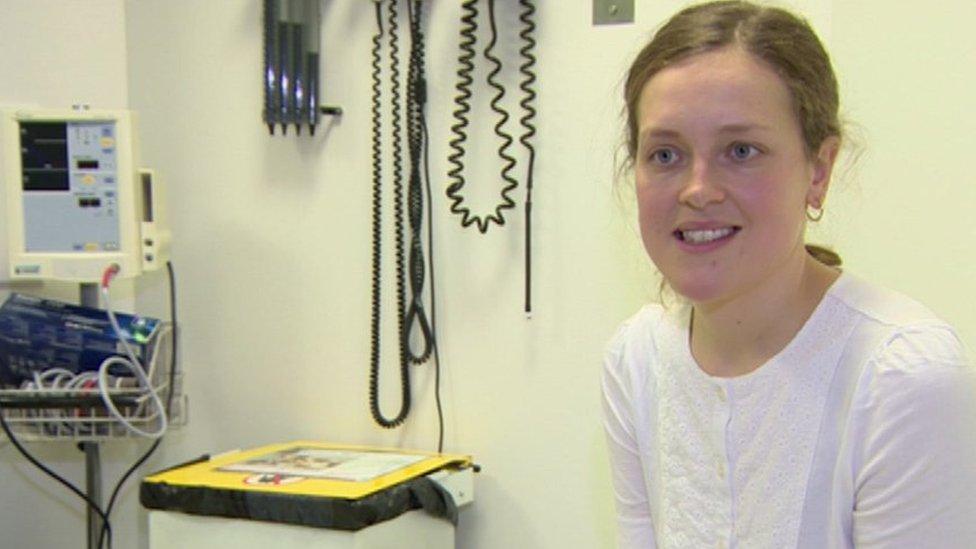 Sophia Pemberton sitting in a hospital consulting room surrounded by medical equipment.