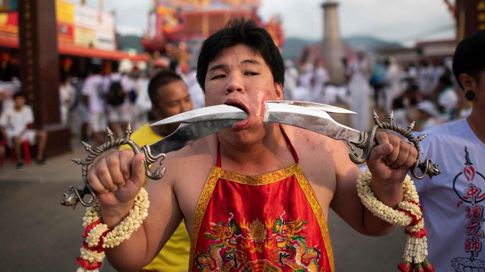 A devotee with two swords pierced through his cheek